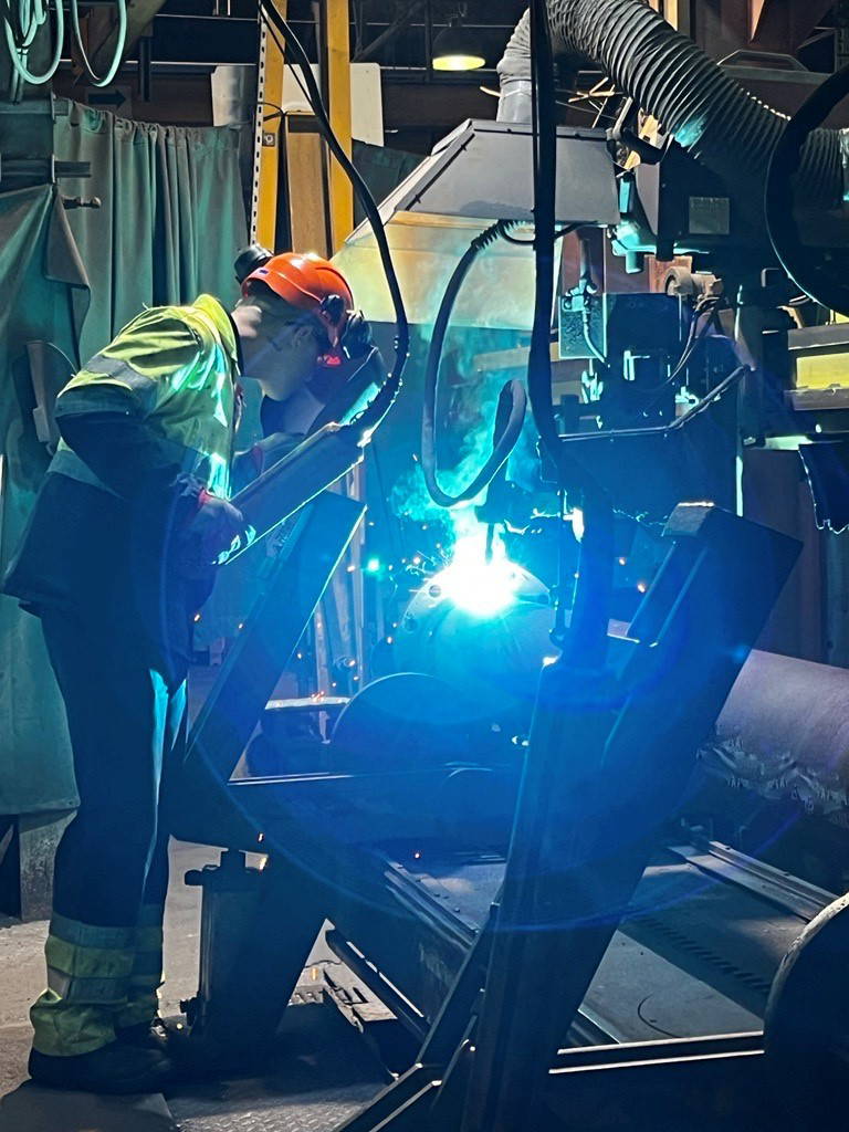 Welding man welding at a station