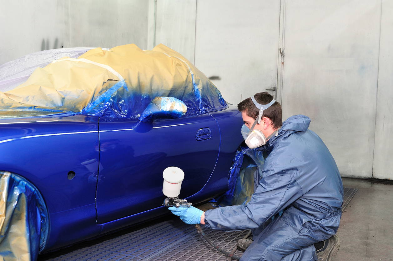 Worker painting a car. Car Spray Painting Process